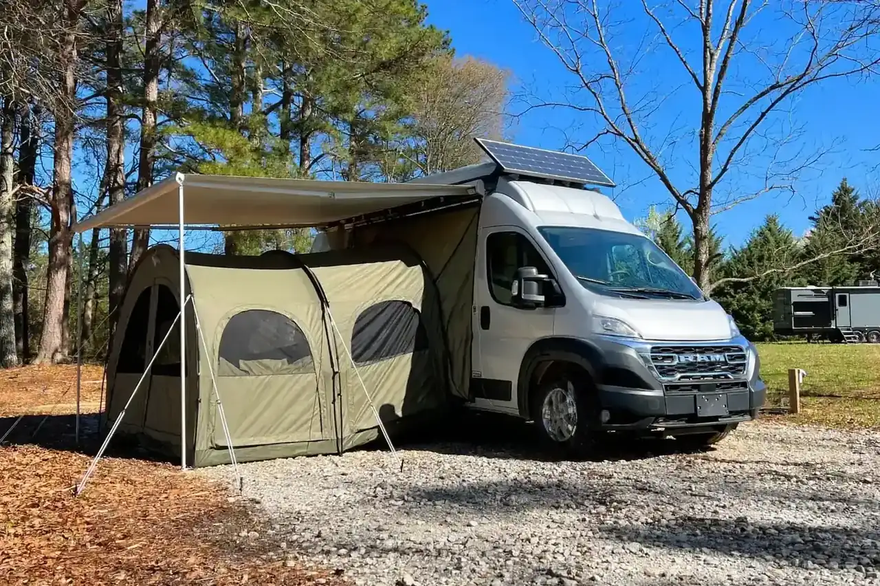Silver Ram ProMaster with a drive-away tunnel tent awning in a pine forest