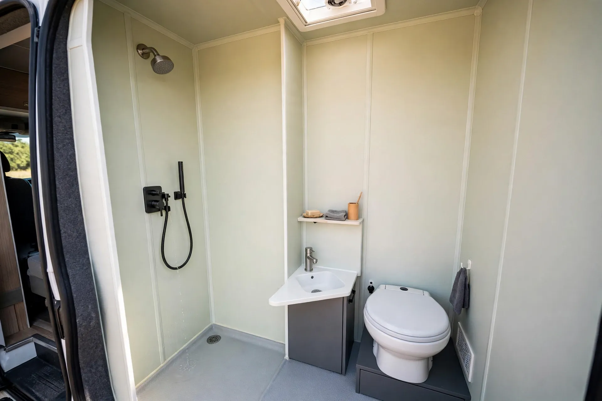 Tiny all-in-one micro wet bath in a short wheelbase camper van with shower, toilet and corner sink