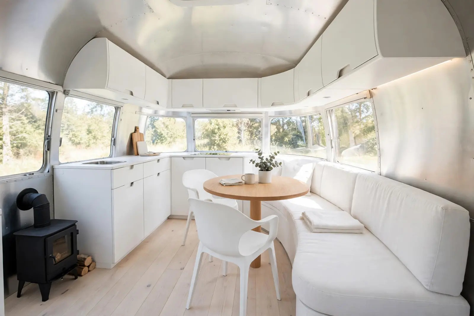 Renovated vintage Airstream interior in all-white Scandinavian minimalism with pale ash floors