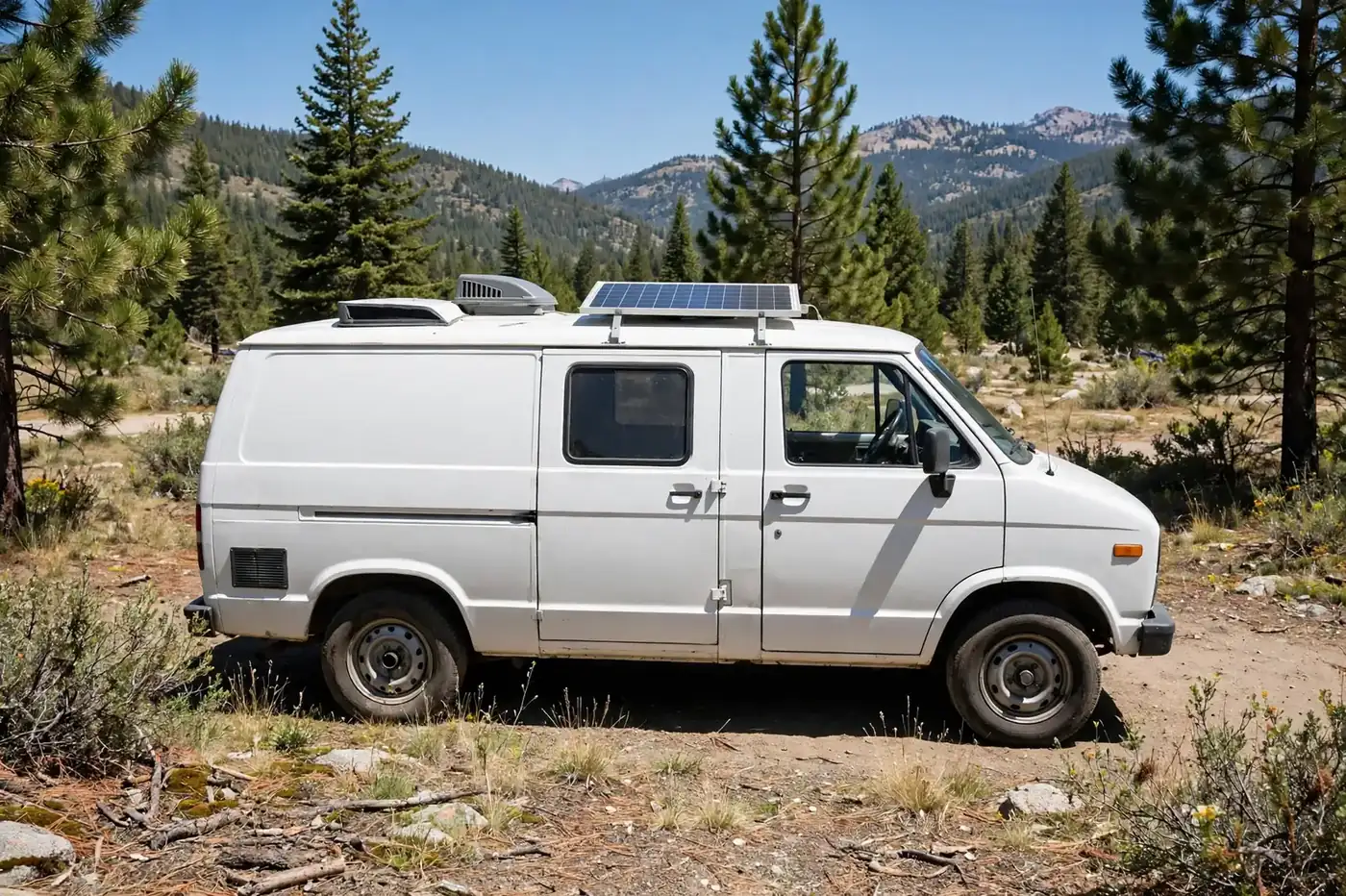 Budget DIY camper van exterior parked at a sunny campsite